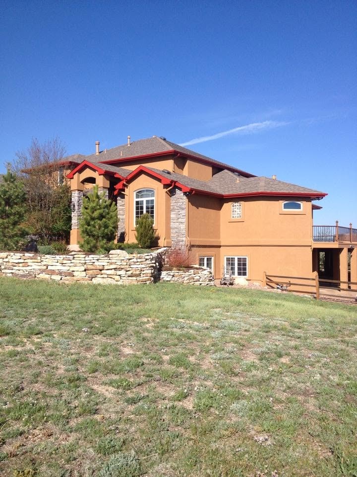 Suburban home exterior with stone landscaping — painting project in Fountain, CO